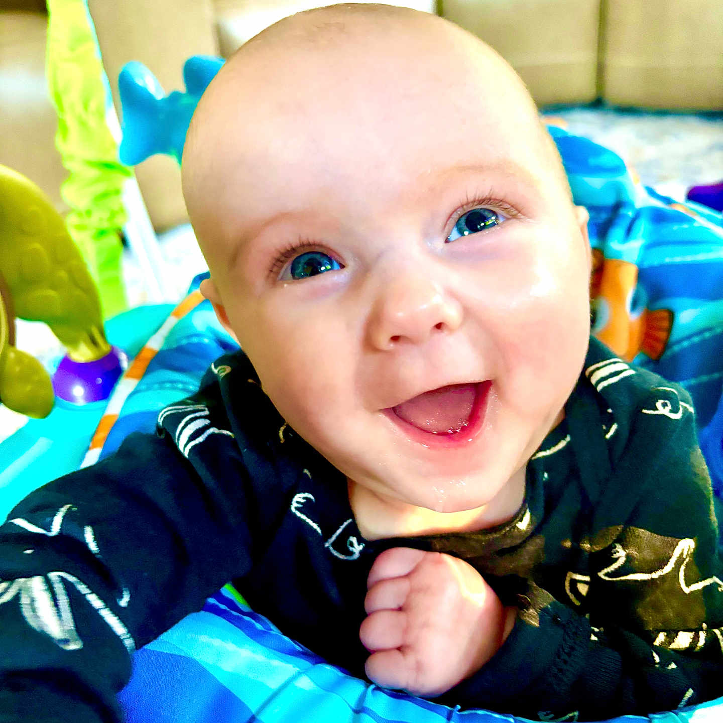 Sophia is registered to the contest to win money with this photo: baby, blue_eyes, child, closeup, clothing, colorful, couch, cute, face, hand, happy, indoor, infant, joyful, living_room, person, playtime, portrait, smile, toy