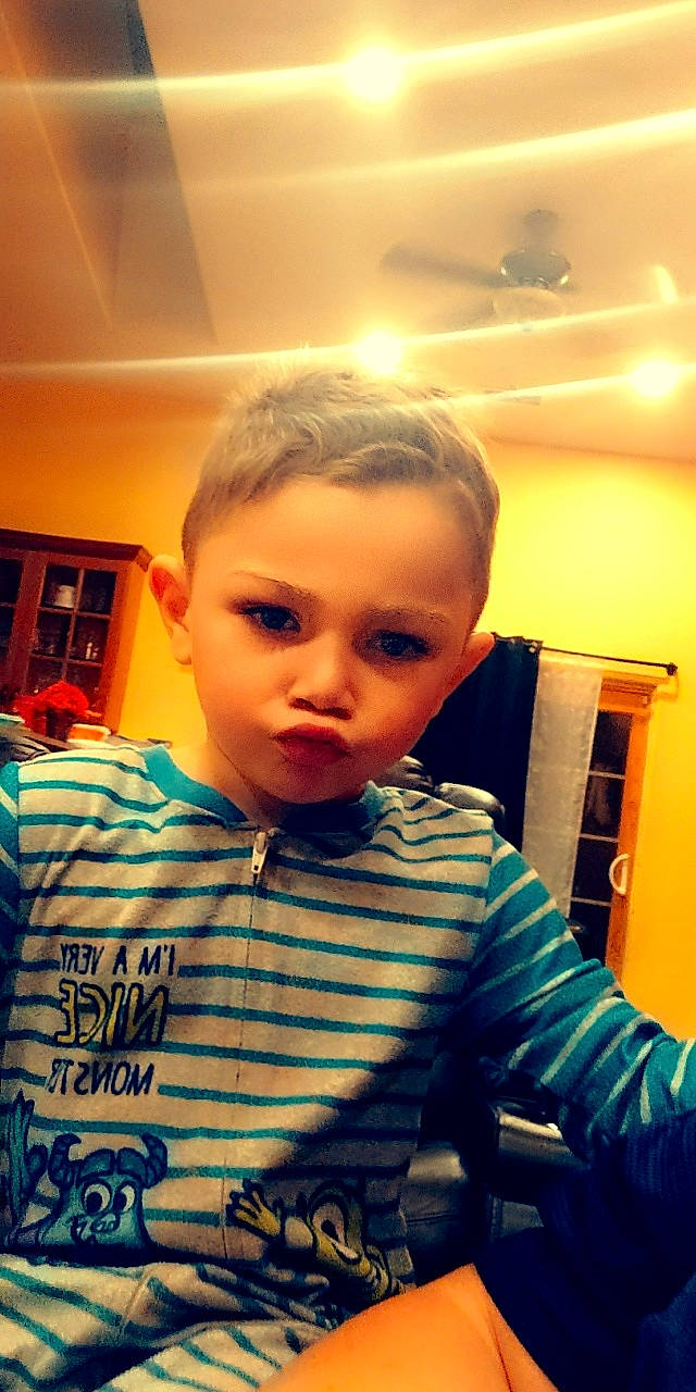 Malakai is registered to the contest to win money with this photo: baby_toddler_clothing, cheek, child, chin, cool, electric_blue, eyelash, flooring, forehead, fun, hairstyle, happy, nose, pattern, person, room, sitting, sleeve, standing, t_shirt