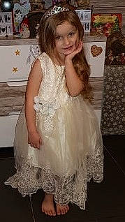 Lyna participe au concours pour gagner de l'argent avec cette photo : bridal_party_dress, brown_hair, ceremony, child, child_model, clothing, dress, fashion_accessory, lace, long_hair, person, smile, toddler, white