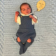 Xander is registered to the contest to win money with this photo: baby, newborn, knitwear, blue, blanket, crochet, infant, clothing, laying, wooden_tag, cute, small, peaceful, portrait, child, soft, texture, cozy, resting, indoors