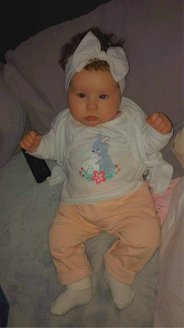 Lola participe au concours pour gagner de l'argent avec cette photo : baby, baby_toddler_clothing, cheek, comfort, cool, eye, eyebrow, finger, head, human_body, iris, lip, mouth, nose, person, pink, product, skin, sleeve, textile