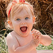 Victoire participe au concours pour gagner de l'argent avec cette photo : baby, child, happy, clapping, headband, red, outdoor, grass, haystack, water_droplets, skin, smile, expression, portrait, summer, sunlight, cute, bare_shoulders, playful, person