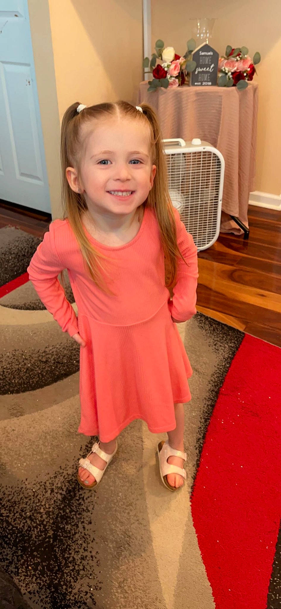 Harper is registered to the contest to win money with this photo: baby_toddler_clothing, blond, dress, face, flooring, fun, happy, hardwood, head, human_leg, iris, joy, leg, magenta, person, pink, skin, sleeve, smile, toddler