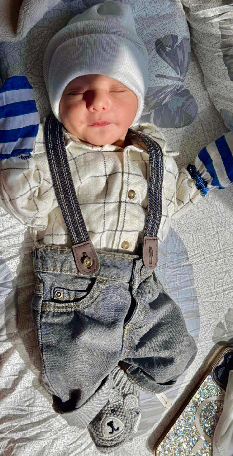 Rayshan is registered to the contest to win money with this photo: baby, infant, sleeping, hat, shirt, suspenders, denim, pants, slippers, bear, quilt, blanket, pattern, sunlight, shadow, phone_case, cozy, cute, child, indoor