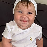 Maria participe au concours pour gagner de l'argent avec cette photo : baby, child, smile, headband, bow, white_clothing, pacifier, sitting, couch, indoor, cute, chubby, happy, face, person, infant, skin, young_child, portrait, small_hand