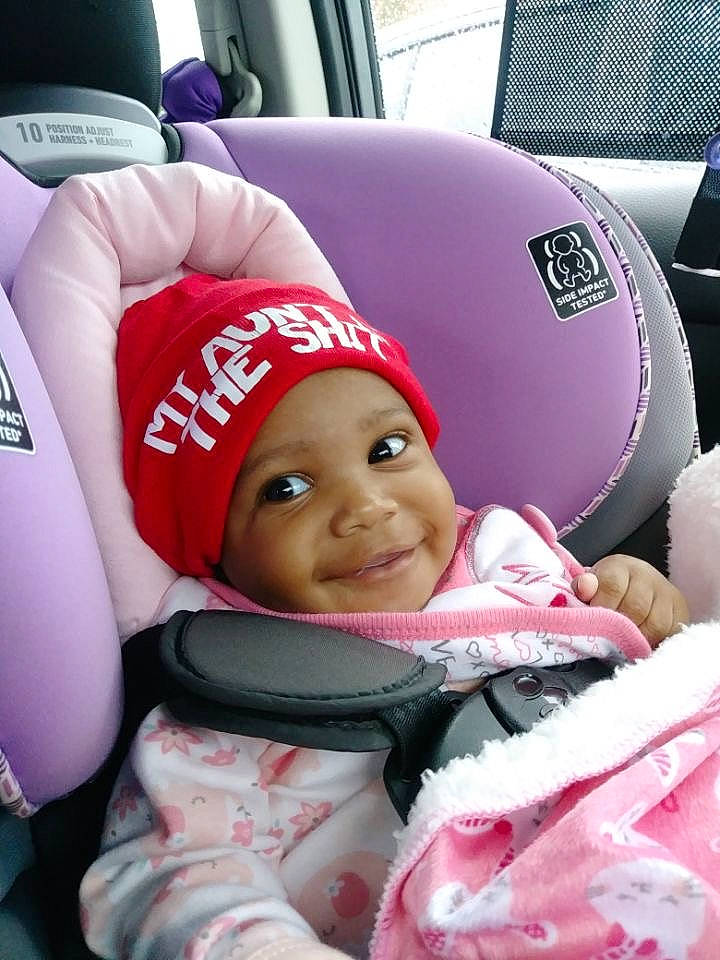 Neriah is registered to the contest to win money with this photo: baby, car, car_seat, child, headgear, headwear, joy, person, pink, toddler, vehicle
