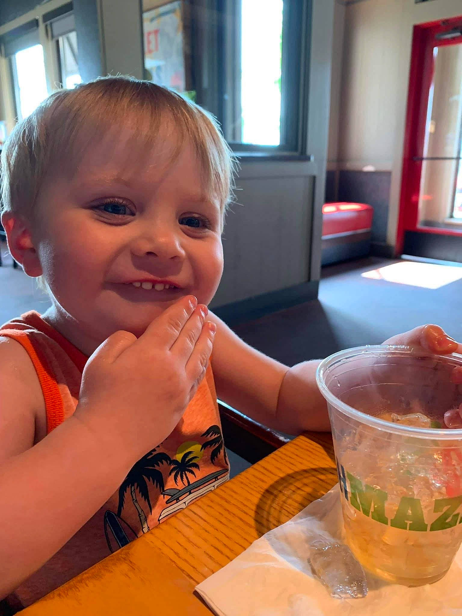 Spencer is registered to the contest to win money with this photo: chair, child, cocktail, comfort_food, cuisine, dish, drinking_straw, food, fun, happy, ingredient, joy, person, plate, smile, soft_drink, table, tableware, thumb, toddler