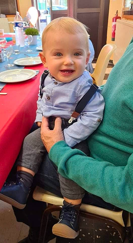 Elio a rejoint le concours — aidez-le/la à gagner de superbes lots ! baby, baby_toddler_clothing, boot, chair, child, event, flooring, fun, green, happy, head, joy, lap, leisure, person, plate, sitting, skin, smile, table