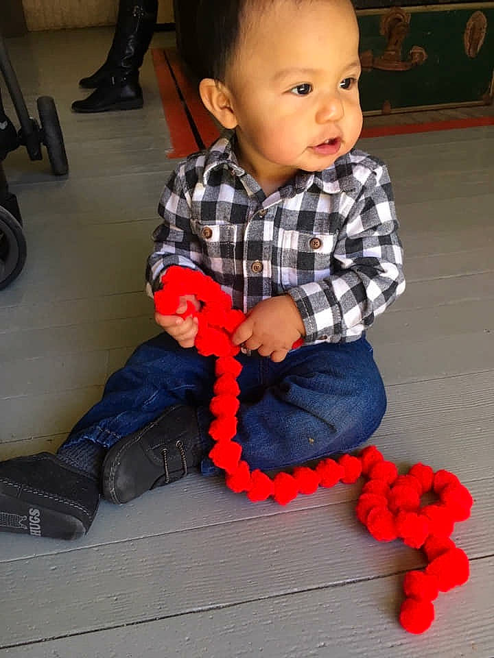 Mikael is registered to the contest to win money with this photo: child, day, fun, girl, infant, person, play, product, red, sitting, standing, textile, toddler