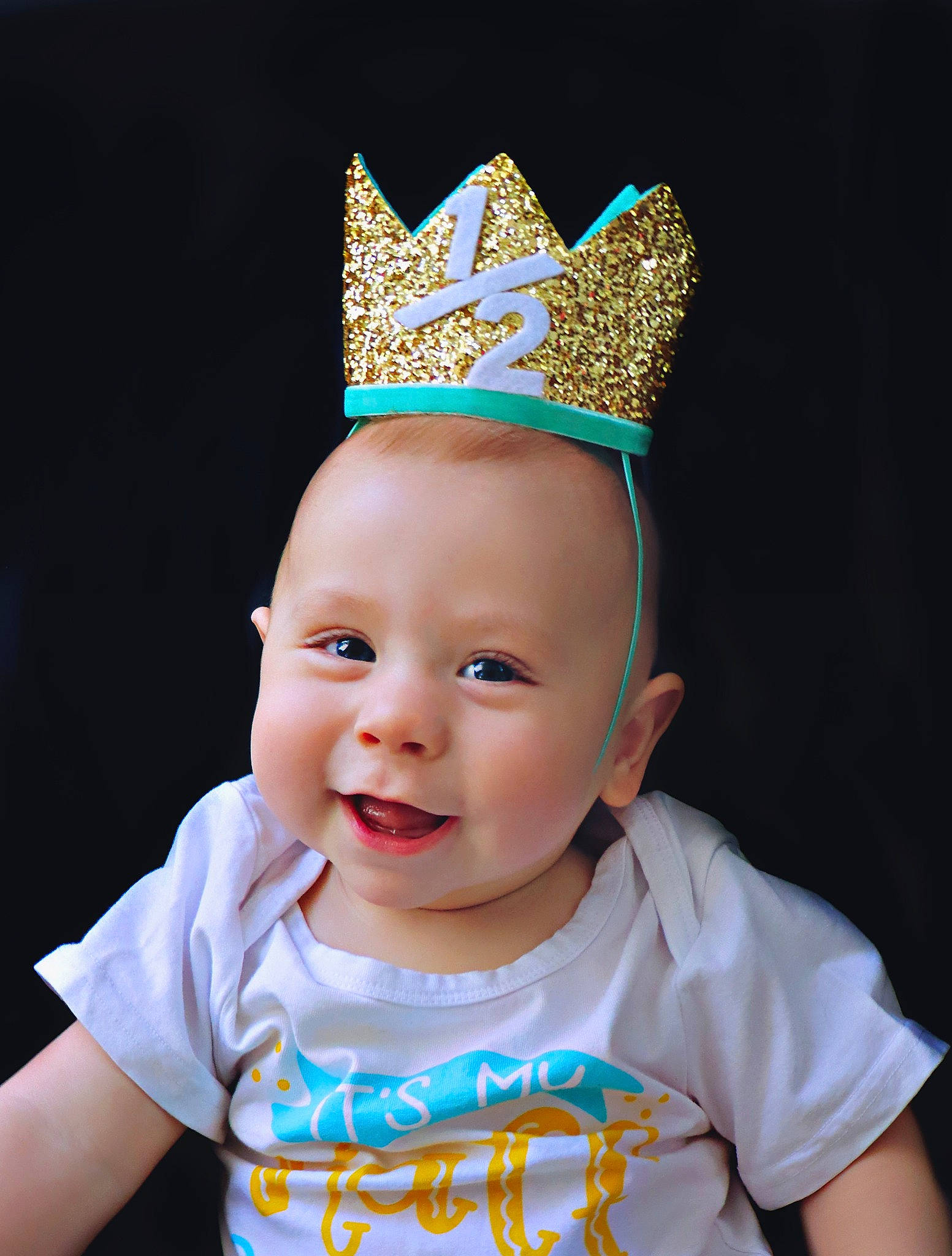 Daniel is registered to the contest to win money with this photo: baby, baby_toddler_clothing, blue, cap, chin, costume_hat, crown, happy, hat, head, headgear, headpiece, jewellery, joy, party_hat, party_supply, person, sleeve, smile, tiara