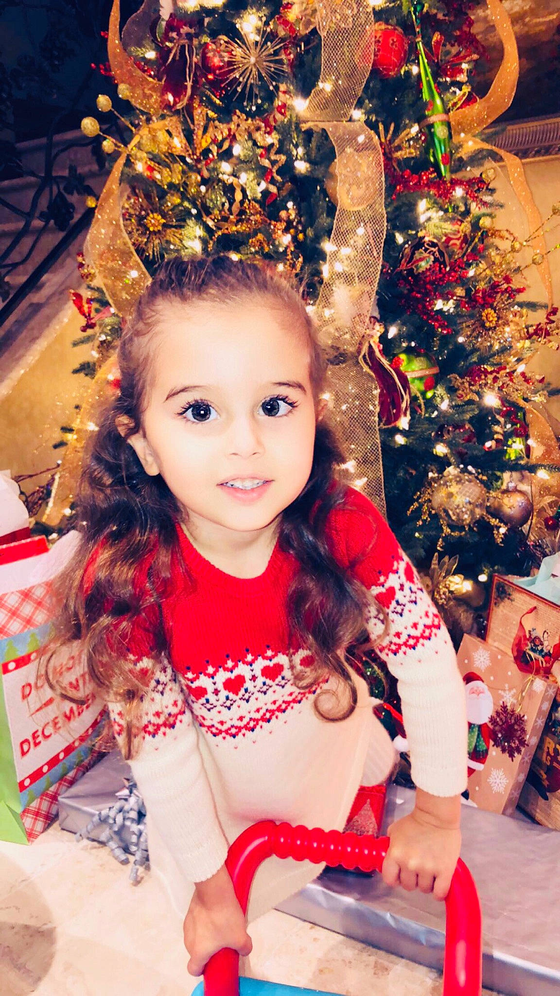 Lara is registered to the contest to win money with this photo: child, child_model, christmas, christmas_decoration, christmas_eve, christmas_tree, event, fashion_accessory, hair, hair_accessory, hairstyle, head, headpiece, holiday, interior_design, long_hair, person, smile, toddler, tradition