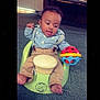 Kyngstun joined the competition — help win amazing prizes! baby, child, sitting, toy, colorful_toy, suspenders, khaki_pants, green_baby_seat, indoor, carpet, couch, home, playful, curious, infant, person, foot, shirt, striped_shirt, smiling