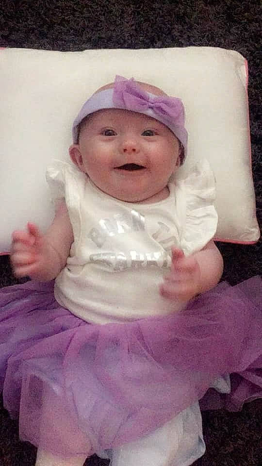 Connie is registered to the contest to win money with this photo: child, face, fun, girl, hair_accessory, head, headgear, headwear, human_hair_color, infant, iris, lilac, person, pink, product, purple, skin, smile, textile, toddler