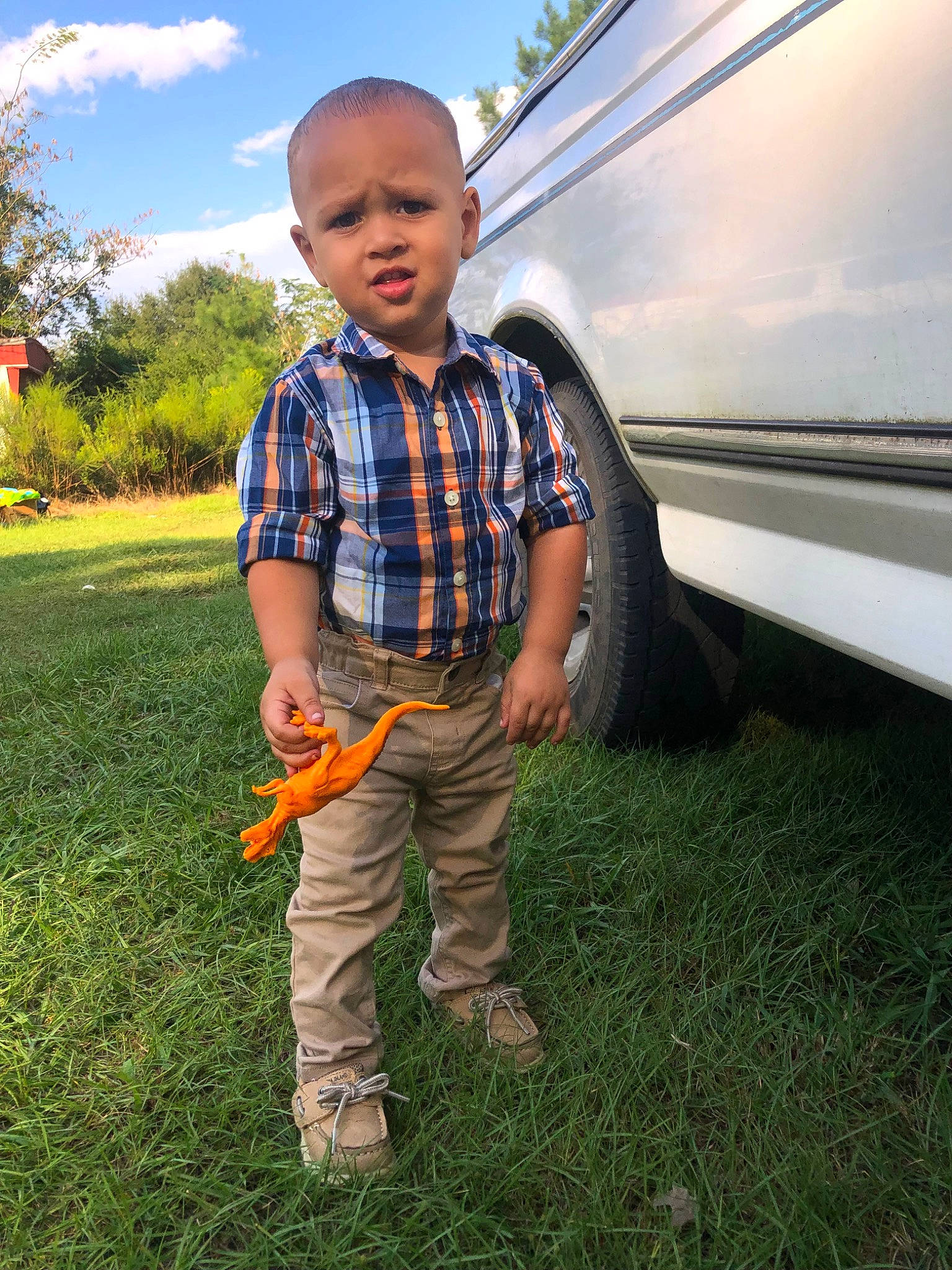 Jamarcus is registered to the contest to win money with this photo: automotive_design, automotive_lighting, automotive_tire, bumper, car, cloud, fender, grass, happy, motor_vehicle, people_in_nature, person, plaid, plant, sky, tartan, tire, toddler, tree, vehicle_door