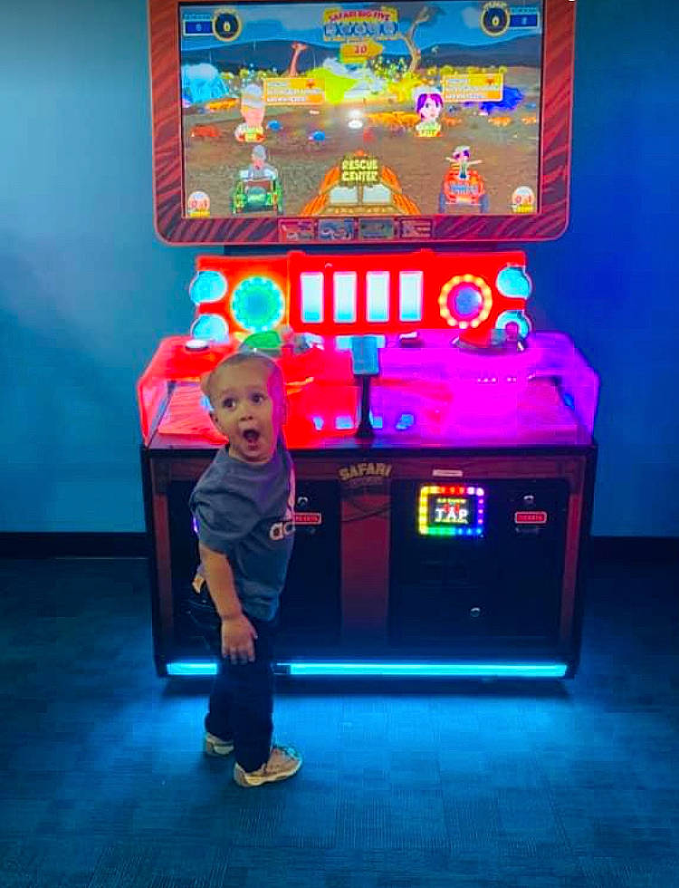 Jamarcus is registered to the contest to win money with this photo: arcade_game, blue, clothing, electric_blue, electronic_device, entertainment, fun, gadget, gamer, indoor_games_and_sports, leisure, machine, magenta, person, recreation, recreation_room, shorts, smile, surprise, t_shirt
