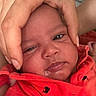 Hugo Lee is registered to the contest to win money with this photo: baby, infant, hand, face, expression, red_clothing, drool, closeup, skin, person, newborn, cute, adorable, protection, care, parent, child, portrait, indoor, human