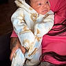 Jyaair joined the competition — help win amazing prizes! baby, infant, onesie, animal_print, clothing, person, hand, tattoo, pink_shirt, indoor, curly_hair, holding, couch, blanket, cozy, portrait, cute, warm, child, young