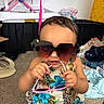 toddler, child, sunglasses, clothing, indoor, carpet, playful, cute, baby, person, fashion, accessories, messy_room, seat, colorful, summer_wear, portrait, fun, young_child, casual