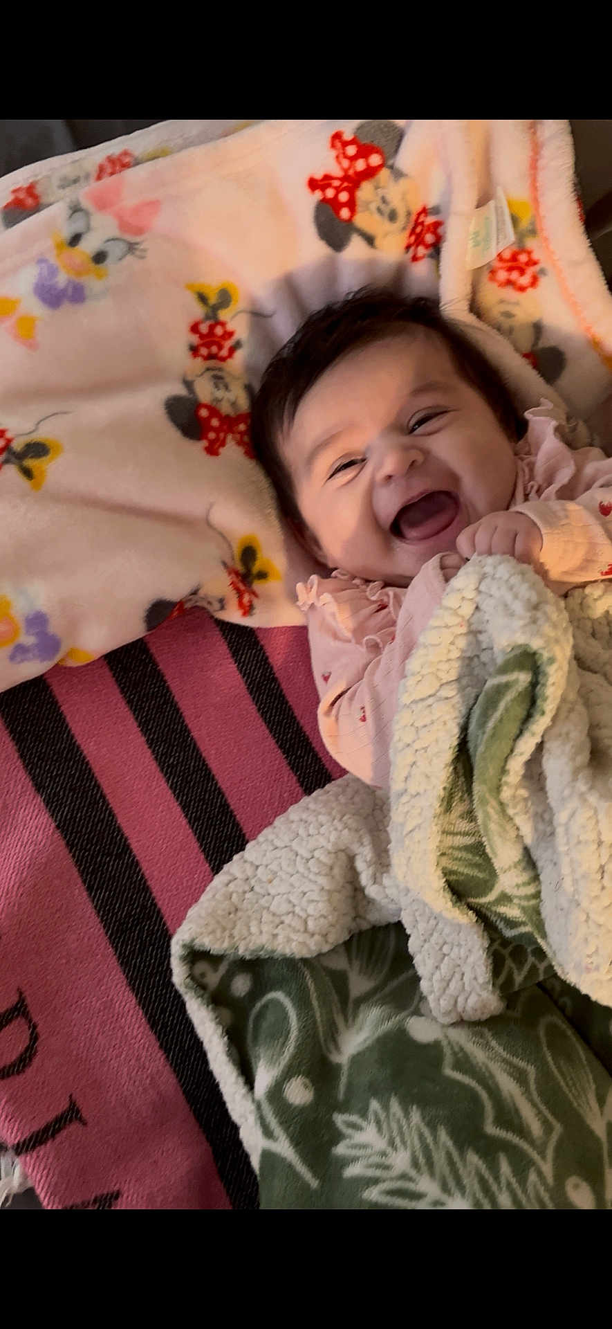 Zendaya joined the competition — help win amazing prizes! baby, smiling, blanket, cozy, cute, face, child, happy, infant, pattern, fabric, colorful, mickey_mouse, minnie_mouse, pink, green, soft, portrait, indoors, clothing