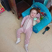 Amanda a rejoint le concours — aidez-le/la à gagner de superbes lots ! bottle, carpet, chair, child, cozy, curly_hair, cute, floor, furniture, indoor, milk, nap, onesie, paw_patrol, relaxed, sleeping, socks, toddler, toy, wooden_furniture