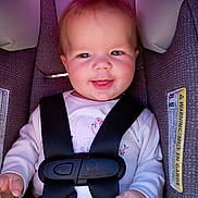 Emeri is registered to the contest to win money with this photo: baby, car_seat, child, smile, face, seatbelt, clothing, infant, safety, cute, hands, head, straps, padding, closeup, portrait, happy, baby_girl, indoors, seat