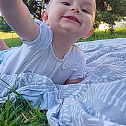Emya participe au concours pour gagner de l'argent avec cette photo : baby, blanket, child, clothing, cute, daylight, grass, greenery, happy, infant, nature, outdoor, person, playful, portrait, reaching, smiling, sunlight, toddler, trees