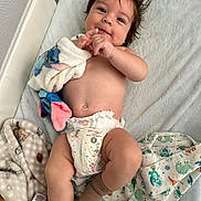 Michael is registered to the contest to win money with this photo: baby, blanket, child, cute, diaper, fabric, face, footwear, hand, happy, indoor, infant, lying_down, patterned_blanket, playpen, plush_toy, skin, smile, sock, soft_texture