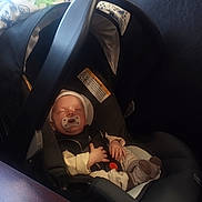 Carter is registered to the contest to win money with this photo: baby, car_seat, pacifier, sleeping, infant, blanket, clothing, soft_toys, headwear, indoors, child, comfort, resting, cozy, seatbelt, newborn, cute, peaceful, warm, sock