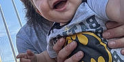 Mavrick joined the competition — help win amazing prizes! baby, child, smiling, batman, onesie, adult, hands, outdoor, sky, fence, bottle, sippy_cup, beard, watch, jeans, person, happy, closeup, portrait, daylight