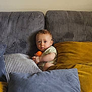 Noah participe au concours pour gagner de l'argent avec cette photo : baby, child, pillow, couch, soft, orange_ball, curious, indoor, seated, cozy, plush, furniture, home, cute, infant, comfort, person, casual, relaxed, young