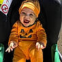 baby, pumpkin_costume, car_seat, orange, smiling, happy, child, infant, costume, cute, holiday, jack_o_lantern, seat, clothing, indoors, person, headwear, celebration, portrait, seatbelt