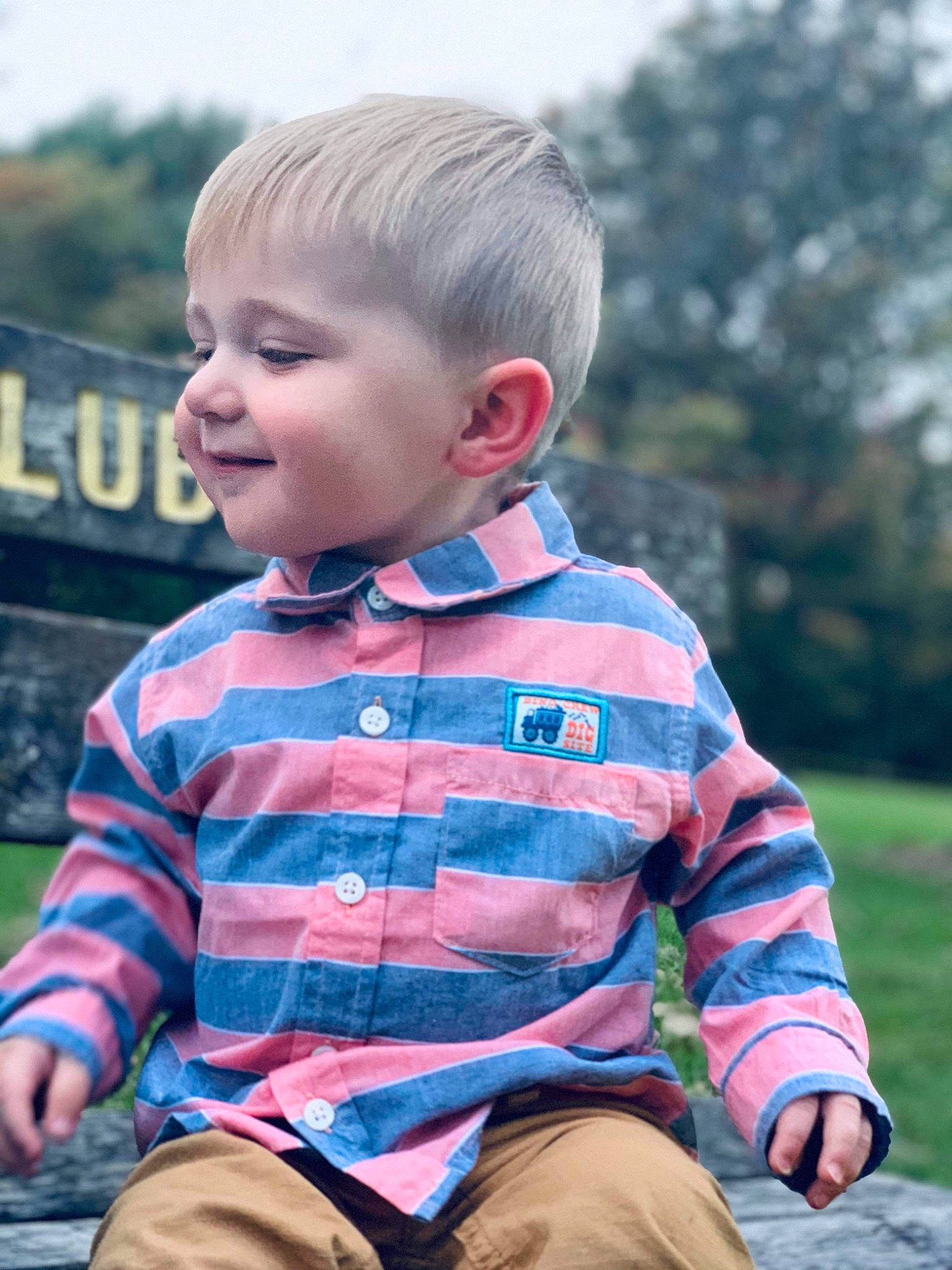 Brysin is registered to the contest to win money with this photo: baby, cheek, child, design, eye, grass, male, outerwear, pattern, people, person, photography, plaid, play, sitting, skin, sleeve, smile, toddler, tree