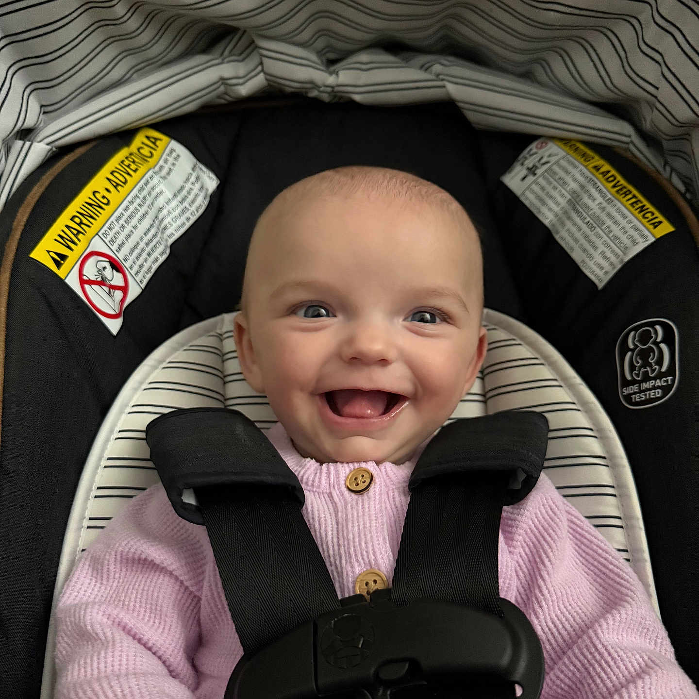 Paisley is registered to the contest to win money with this photo: baby, car_seat, child, closeup, clothing, cute, face, happy, head, indoor, infant, person, pink_sweater, portrait, safety_harness, seat, seat_belt, smiling, stripes, warning_label