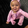 baby, child, infant, smiling, happy, portrait, pink_outfit, headband, bow, butterfly_pattern, sitting, couch, blanket, black_background, indoor, cute, face, eyes, baby_girl, photography