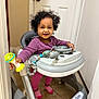 toddler, child, baby_walker, toy, indoor, smiling, curly_hair, purple_clothing, pink_socks, floor_tile, door, door_handle, baby, playful, person, walker, happy, standing, young_child, home
