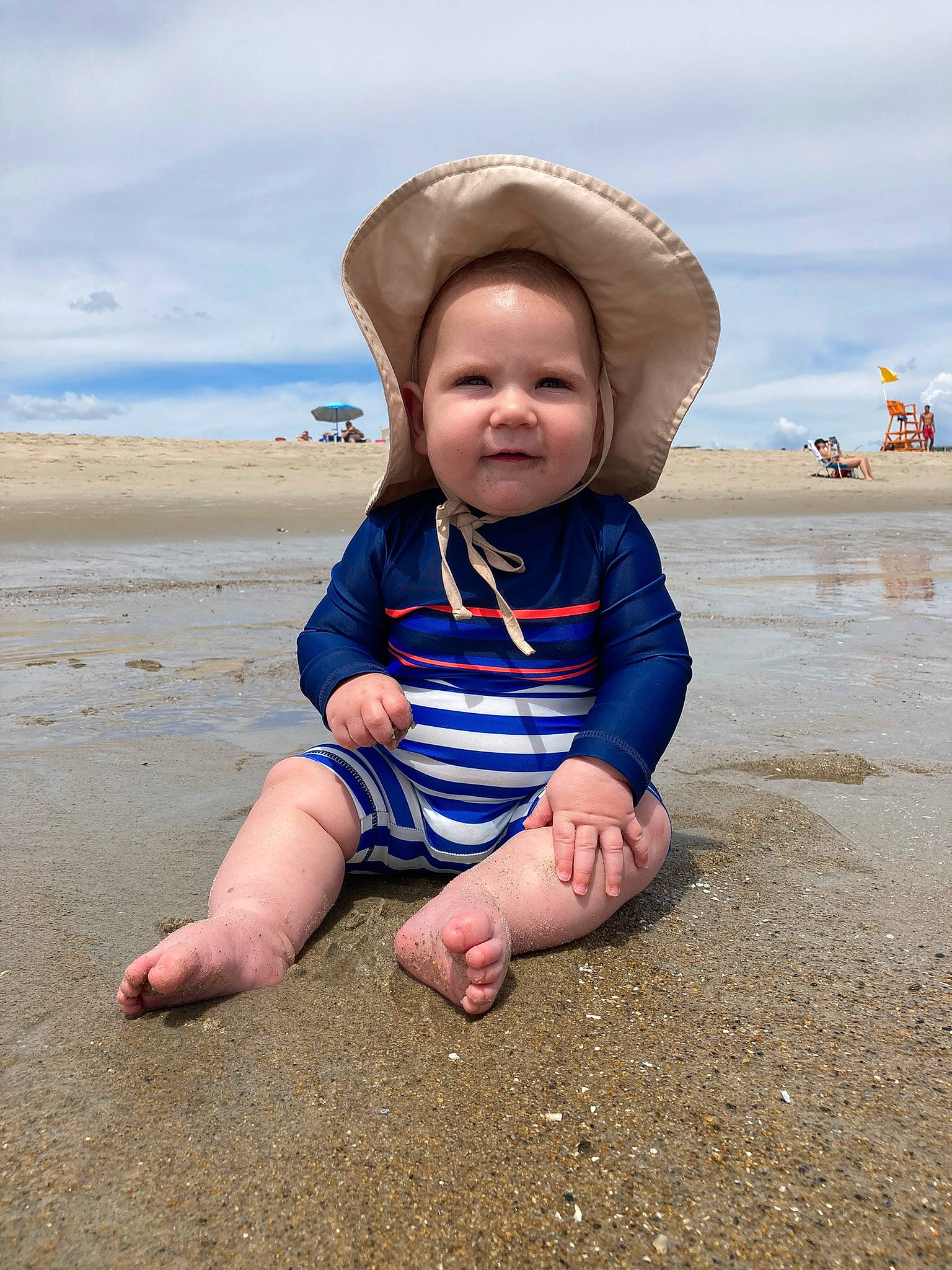 Henry is registered to the contest to win money with this photo: azure, baby, baby_toddler_clothing, beach, cloud, coastal_and_oceanic_landforms, flash_photography, fun, happy, hat, landscape, natural_environment, people_in_nature, people_on_beach, person, sand, shore, sky, sun_hat, toddler