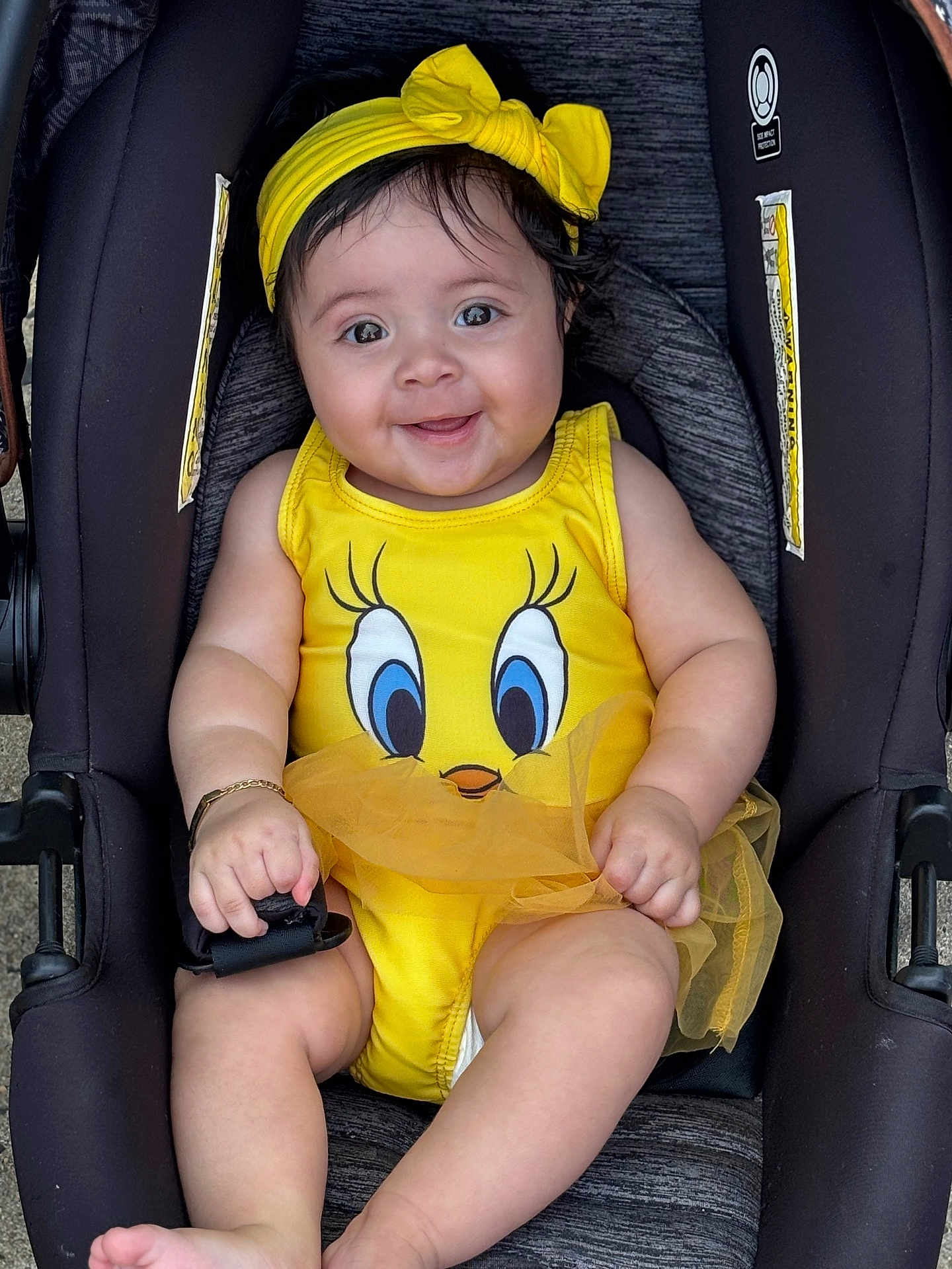 Denali Selah joined the competition — help win amazing prizes! baby, child, smile, yellow_outfit, headband, stroller, happy, infant, cute, portrait, sitting, clothing, face, skin, hand, foot, accessory, toddler, playful, outdoor