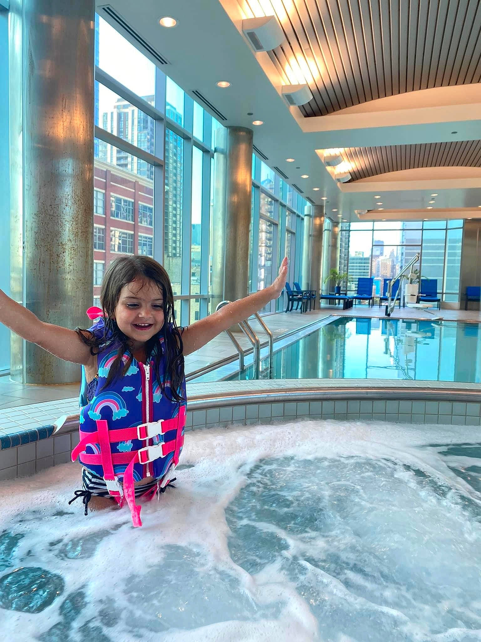 Mila is registered to the contest to win money with this photo: azure, building, child, fun, happy, joy, leisure, leisure_centre, person, personal_protective_equipment, physical_fitness, recreation, resort, smile, swimming_pool, toddler, tourism, travel, vacation, water