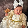 baby, bow, cardigan, child, clothing, cute, dress, face, hand, happy, headband, indoor, infant, leaf, person, polka_dots, portrait, sitting, smiling, warm