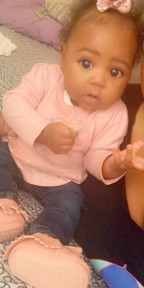 Deanna is registered to the contest to win money with this photo: arm, baby, cheek, child, eye, face, finger, head, leg, lip, mouth, muscle, neck, nose, person, pink, sitting, skin, surprise, thumb