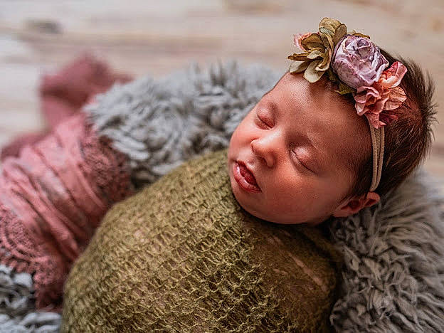 Baylee is registered to the contest to win money with this photo: baby, brown_hair, cap, child, eye, fashion_accessory, fur, grass, happy, headband, headpiece, knit_cap, pattern, person, sunglasses, toddler, toy, vertebrate, wood, wool