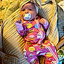 Rylee joined the competition — help win amazing prizes! baby, infant, pacifier, headwrap, onesie, pink_clothing, blanket, cushion, patterned_clothing, smiling_face, cute, indoors, child, lying_down, soft_toys, colorful_background, sleepwear, newborn, cozy, comfort