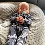 Ryker is registered to the contest to win money with this photo: baby, sleeping, pacifier, onesie, camouflage, pillow, soft_texture, infant, cute, peaceful, hands, footed_pajamas, indoor, resting, cozy, head, face, child, nap, comfort