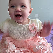 Lynzee is registered to the contest to win money with this photo: baby, child, girl, smiling, sitting, dress, pink, cream, flower, hand, feet, toes, blanket, purple, indoors, face, happy, portrait, cute, infant