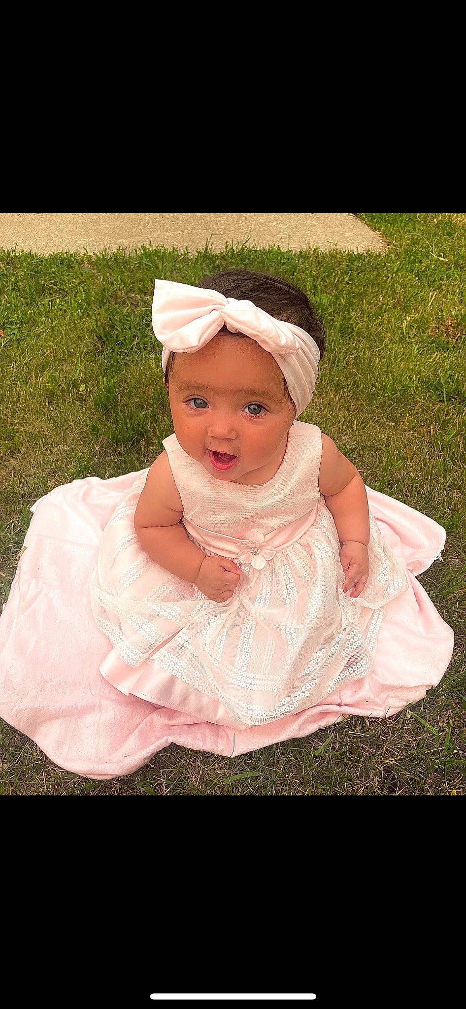 Melani is registered to the contest to win money with this photo: baby, baby_toddler_clothing, cheek, child, chin, dress, eye, face, fashion_accessory, flash_photography, grass, happy, headwear, peach, people_in_nature, person, pink, plant, portrait_photography, sitting