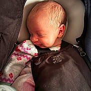 Treazure is registered to the contest to win money with this photo: baby, blanket, car_seat, child, closeup, clothing, comfort, cozy, cute, face, human, indoors, infant, newborn, peaceful, portrait, resting, sleeping, smile, soft