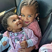 Wynterr is registered to the contest to win money with this photo: baby, toddler, child, car_seat, braided_hair, pink_clothing, hello_kitty, onesie, fuzzy_jacket, cute, smiling, happy, indoor, portrait, people, infant, car_interior, black_hair, holding, seated