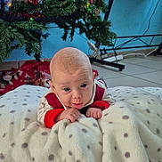 Sylianno participe au concours pour gagner de l'argent avec cette photo : baby, blanket, christmas_tree, decoration, floor, indoor, playful, polka_dot, red_clothing, soft_texture, stick_out_tongue, toddler, toy, white, festive, holiday, cute, child, smiling, cozy