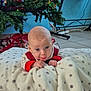 baby, blanket, christmas_tree, decoration, floor, indoor, playful, polka_dot, red_clothing, soft_texture, stick_out_tongue, toddler, toy, white, festive, holiday, cute, child, smiling, cozy