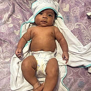 Ezekiel joined the competition — help win amazing prizes! baby, bed, blanket, child, cloth, cute, diaper, hand, holding_hands, hooded_towel, indoors, infant, looking_at_camera, lying_down, patterned, person, purple, skin, soft_texture, towel